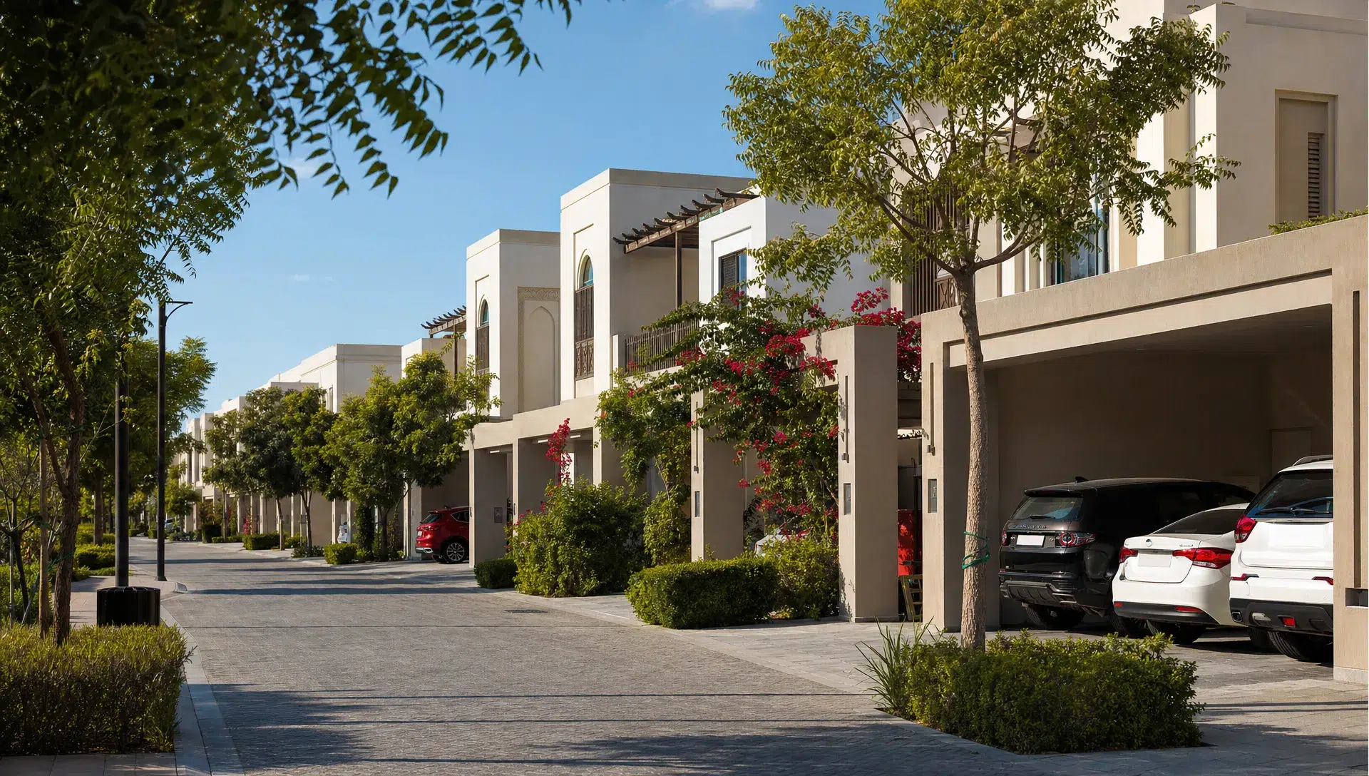 A quiet Abu Dhabi villa community with family houses, shaded streets, landscaped gardens and parked cars outside modern townhouses.